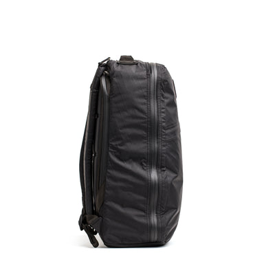 Side view of a black, durable GORUCK GR1 USA - X-PAC rucksack featuring a vertical zipper, waterproof fabric, and adjustable straps.