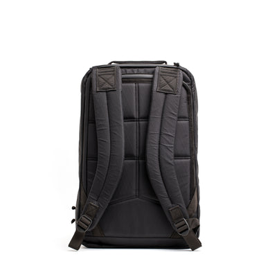 The GORUCK GR1 USA - X-PAC, a black rucksack featuring padded straps and a minimalist design, crafted from waterproof material, is shown from the back against a white background.