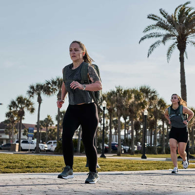 Two people rucking with the Rucker 4.0 on a sunny day, palm trees swaying in the background.