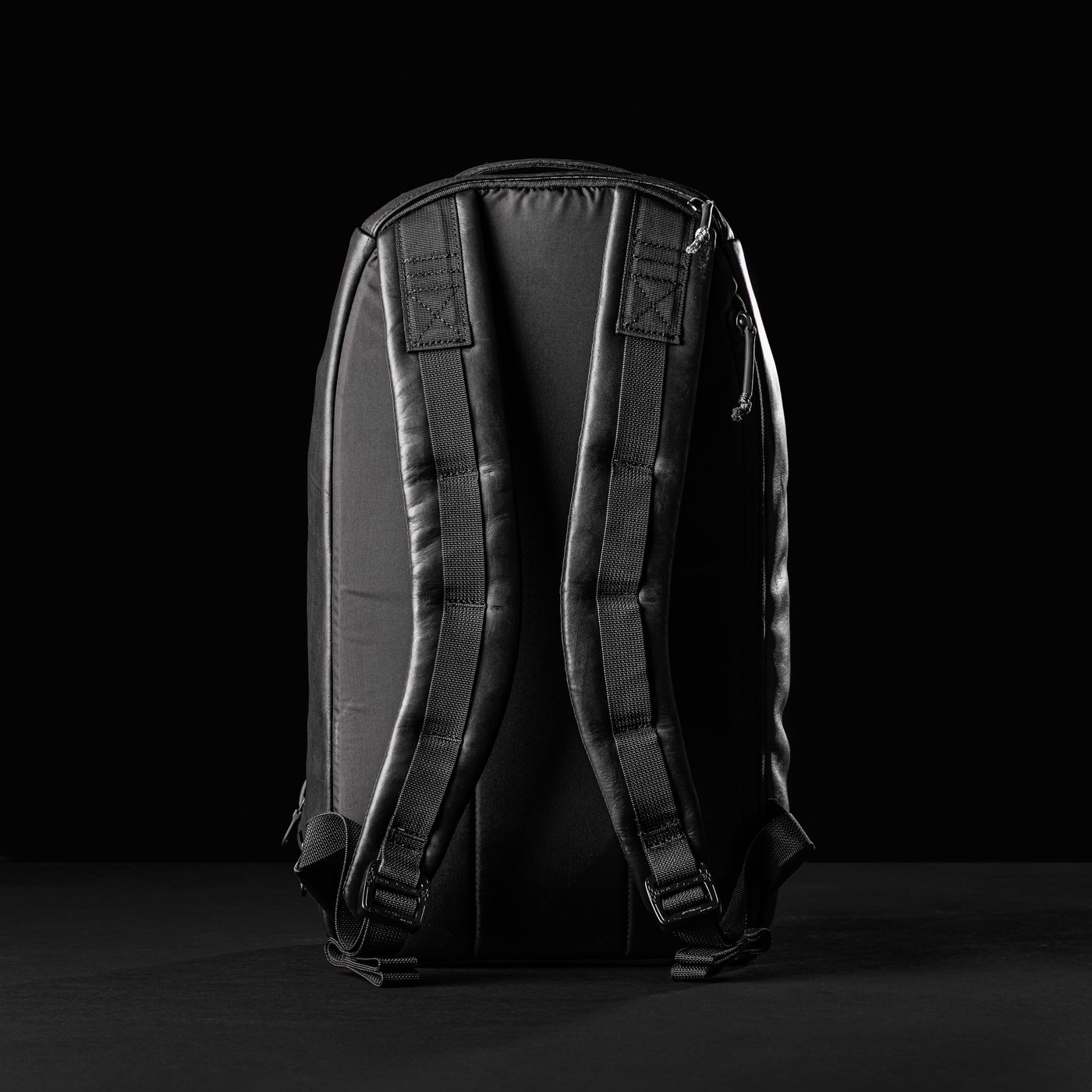 A black backpack, similar to the Bullet Ruck x Carryology - Berserker Viking by GORUCK, stands upright against a dark background. The focus is on the padded shoulder straps and sturdy back panel, highlighting its design for comfort and support on every GRXC program adventure.