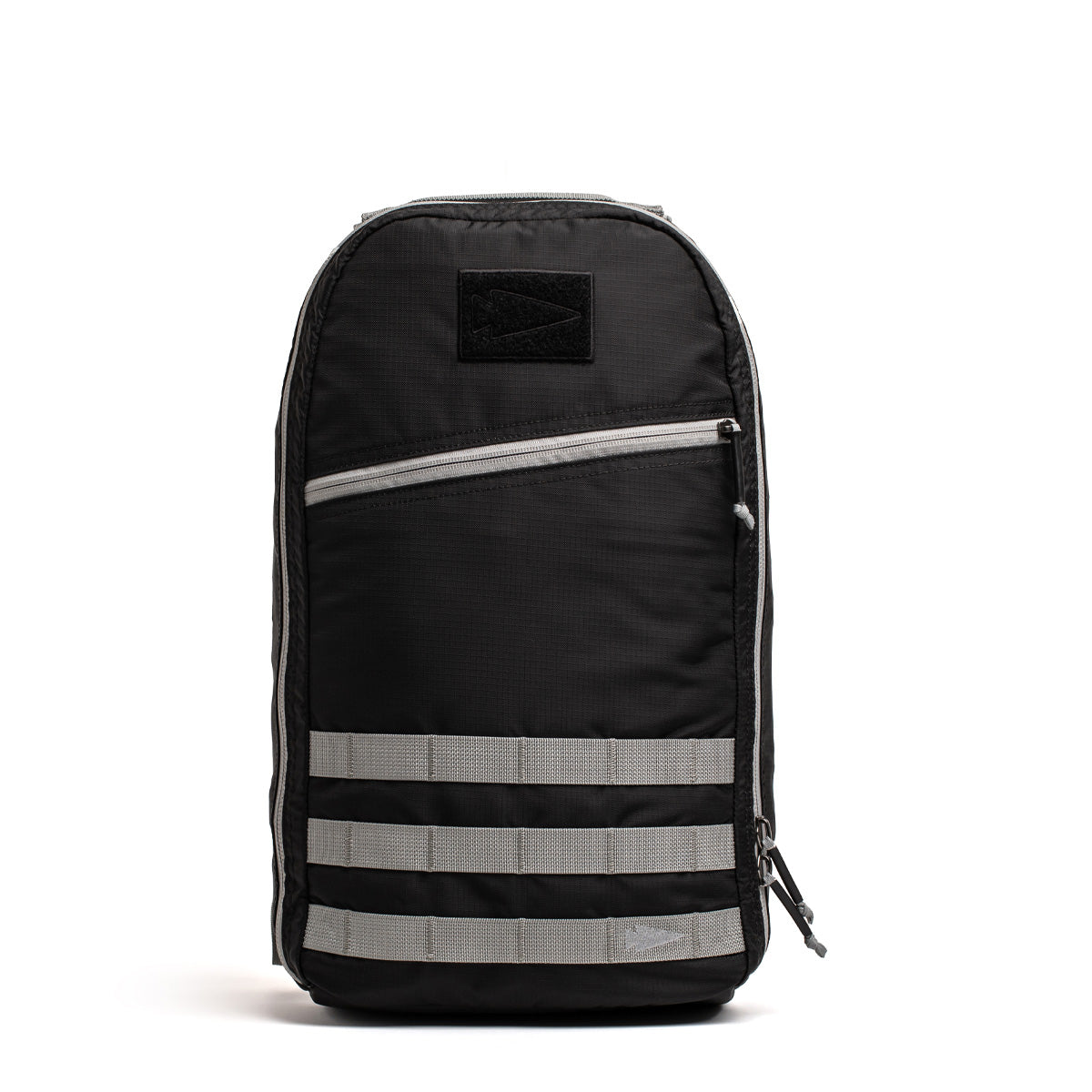 Introducing the Bullet Ruck Laptop - Ripstop ROBIC® - 16L by GORUCK: This black backpack boasts a minimalist design and is constructed from durable ROBIC® Ripstop Nylon. It features light gray horizontal and diagonal accents, along with a small logo patch. The front includes a zippered pocket adorned with three striped bands, while the main compartment comes equipped with a dedicated laptop section and is secured with a zipper.