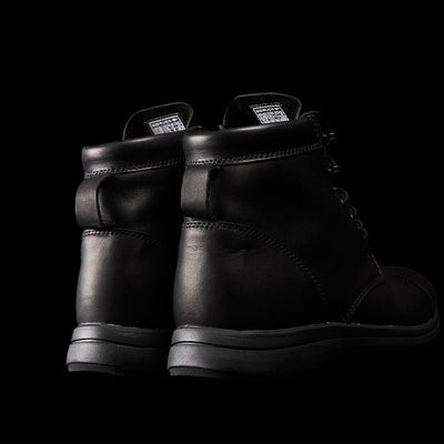 The MACV-1 Traveler x Carryology - Berserker Viking boots from GORUCK are displayed against a dark background, highlighting the rear view. These limited edition boots feature a smooth texture, visible stitching, and a high-top design with laces crafted from water-resistant leather.