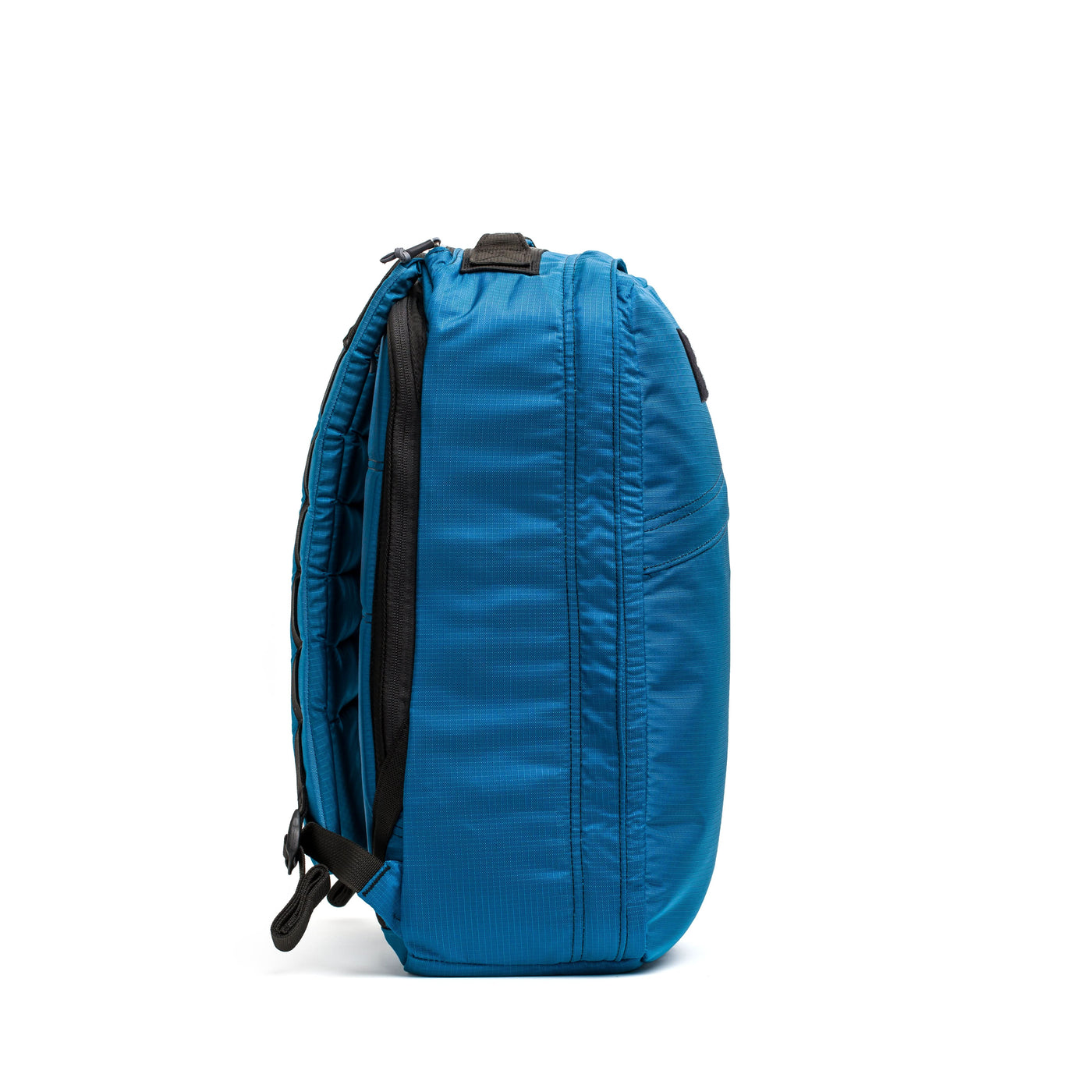 Side view of the GORUCK GR1 USA - Ripstop ROBIC® backpack, showcasing its ultra-lightweight blue design made from 420D Robic Ripstop Nylon with black straps and zippers, set against a white background.