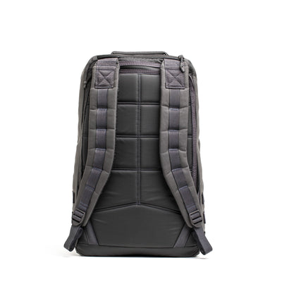 The reverse side of a GORUCK GR1 USA - Cordura backpack in gray and black, featuring padded straps and a quilted texture, highlights the robust rucksack design against a white backdrop.