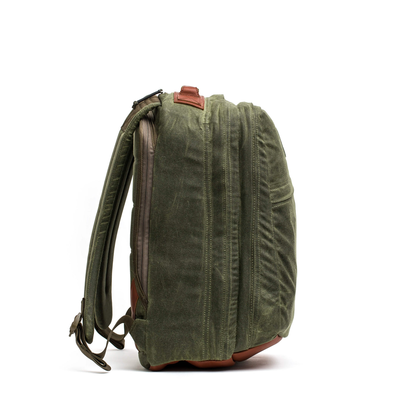 The GR2 - Waxed Canvas by GORUCK is made from green waxed duck canvas with accents of Red Wing leather. It features multiple zippered compartments, padded adjustable straps, and a flat base. The backpack is displayed on a white background, viewed from the side.