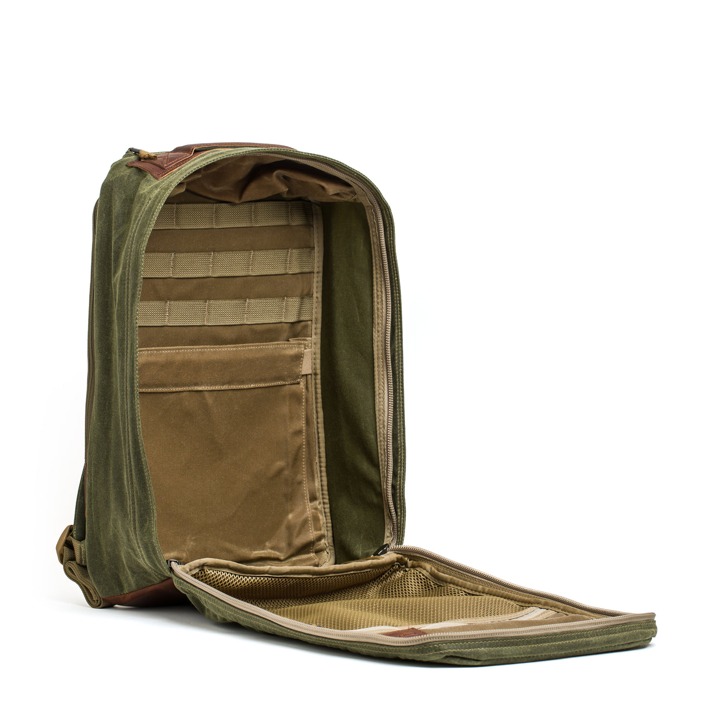 An open olive green GORUCK GR1 USA - Heritage Backpack made from waxed duck canvas features multiple compartments and pockets. The main compartment is fully unzipped, revealing interior storage areas with mesh and fabric sections, ideal for organizing various items.