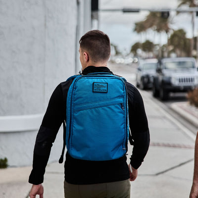 Walking down the city street, a person carries the ultra-lightweight GR1 USA - Ripstop ROBIC® backpack from GORUCK.