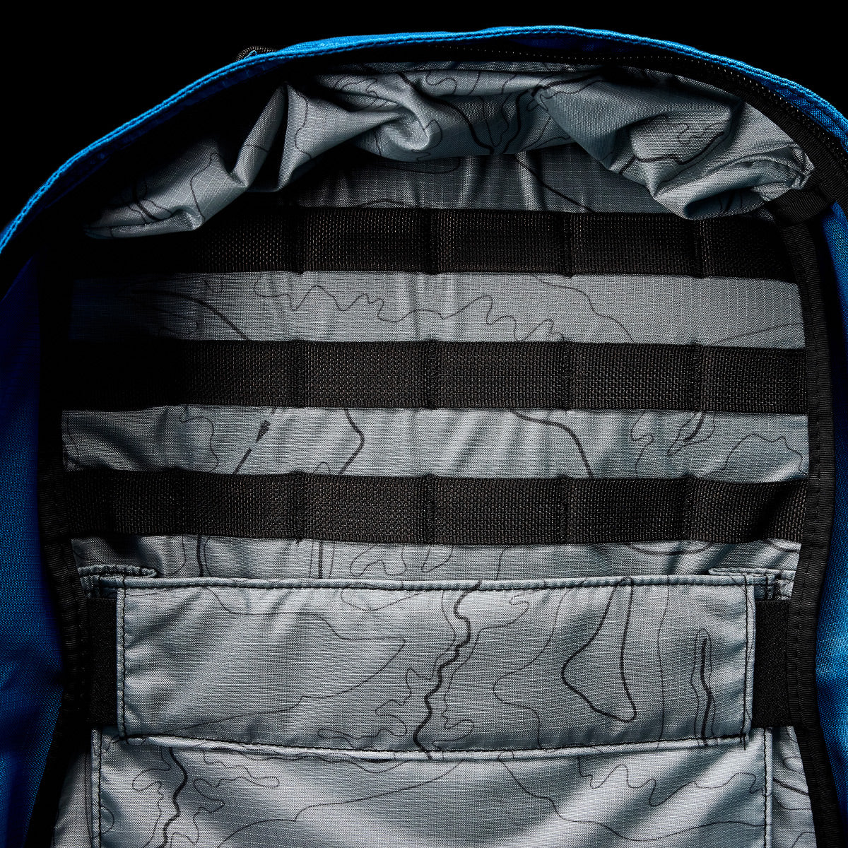 The GR1 USA - Ripstop ROBIC® backpack by GORUCK is crafted from lightweight Ripstop Nylon, featuring a topographical pattern lining and black straps inside. This water-resistant rucksack is both durable and stylish, making it perfect for your adventurous pursuits.