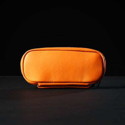 The Echo Field Pocket x Carryology - Berserker Viking by GORUCK is an orange leather pouch set against a dark background, evoking the rugged style favored by Vikings. It features a rounded rectangular design with a zip closure on one side.