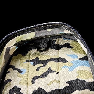 The GORUCK Bullet Ruck Classic - Cordura is a stylish daypack featuring a camouflage pattern and padded straps, all against a sleek black backdrop.