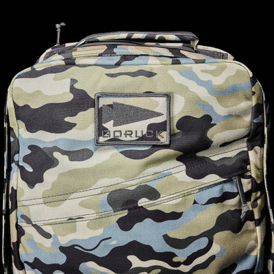 Durable rucksack, the GR1 USA - Cordura by GORUCK, featuring a camouflage design and a GORUCK patch on a black backdrop, evokes the gear of Special Forces.