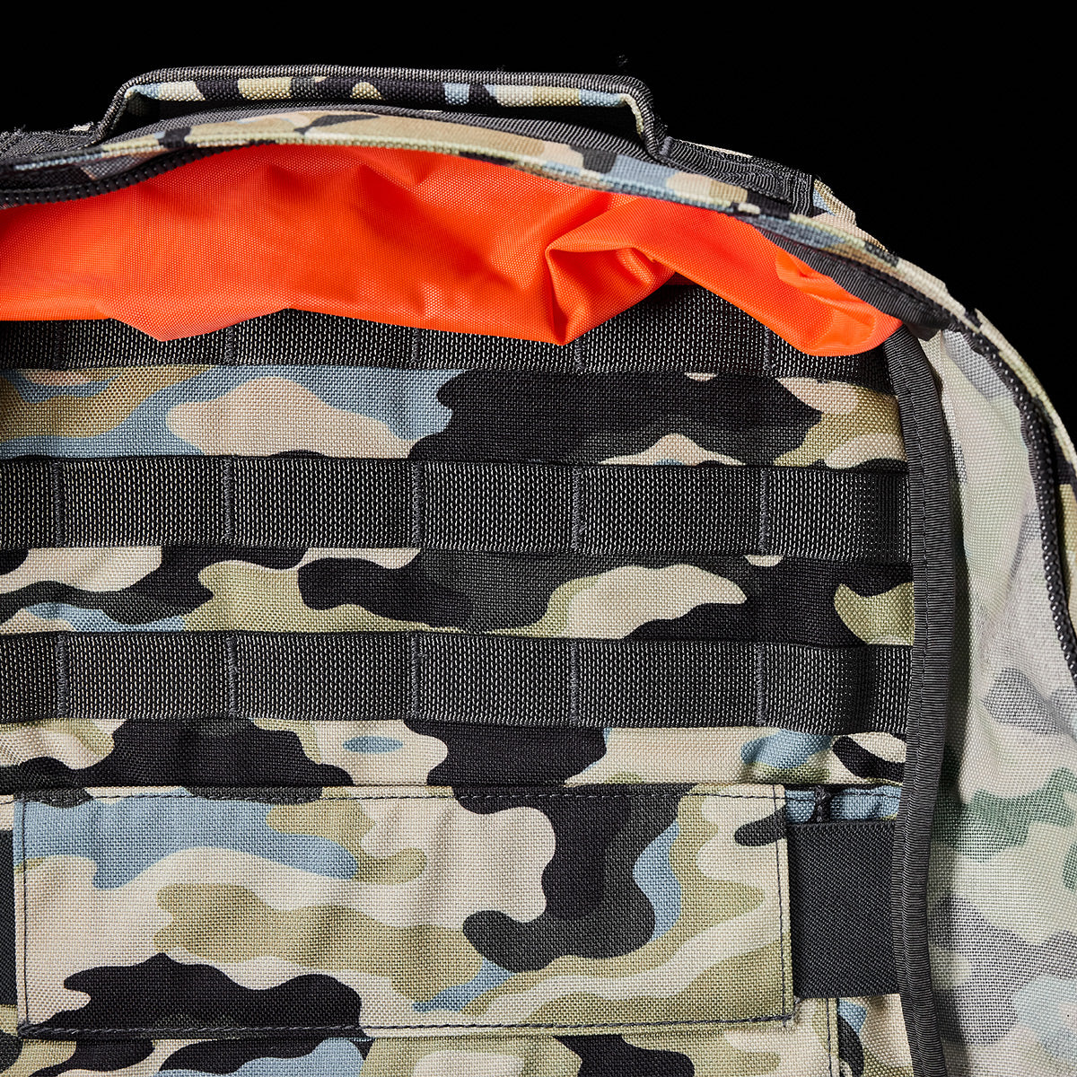 The GR1 USA - Cordura rucksack by GORUCK boasts a rugged open camouflage pattern with a vibrant orange interior, drawing inspiration from Special Forces gear to deliver both style and functionality.