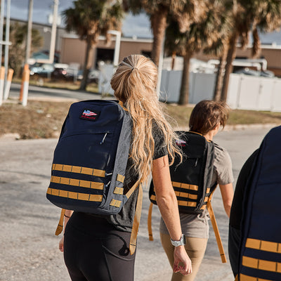 Individuals strolling outdoors with their GR1 USA - Cordura backpacks from GORUCK on a sunny day, resembling Special Forces on a relaxed mission.