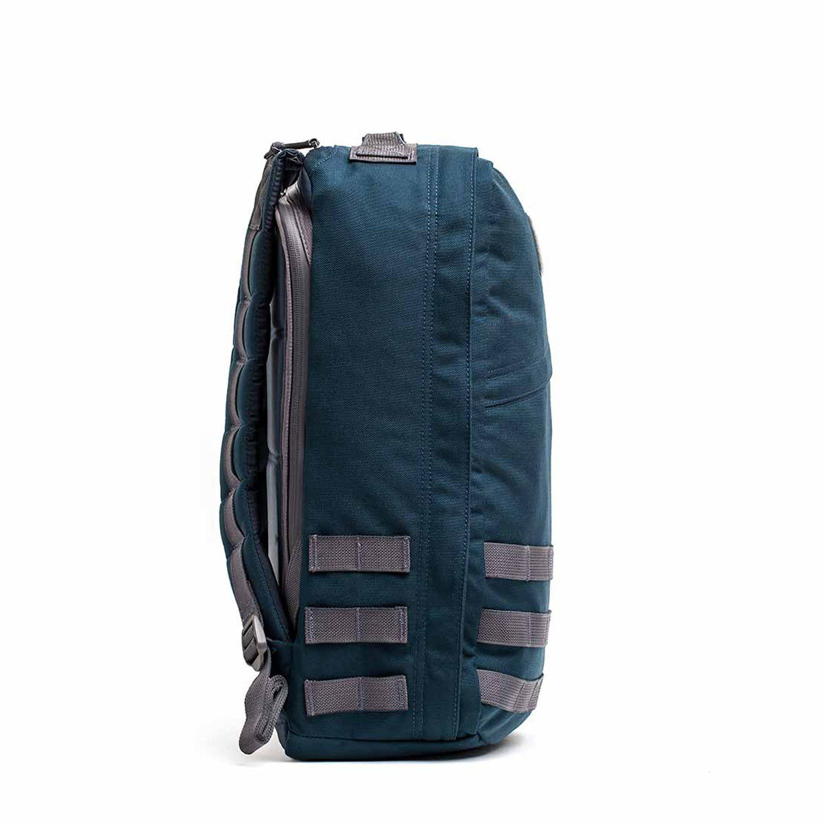 Side view of the GR1 USA - Cordura backpack in blue and gray, crafted with Special Forces grade materials, featuring padded straps and multiple attachment loops.