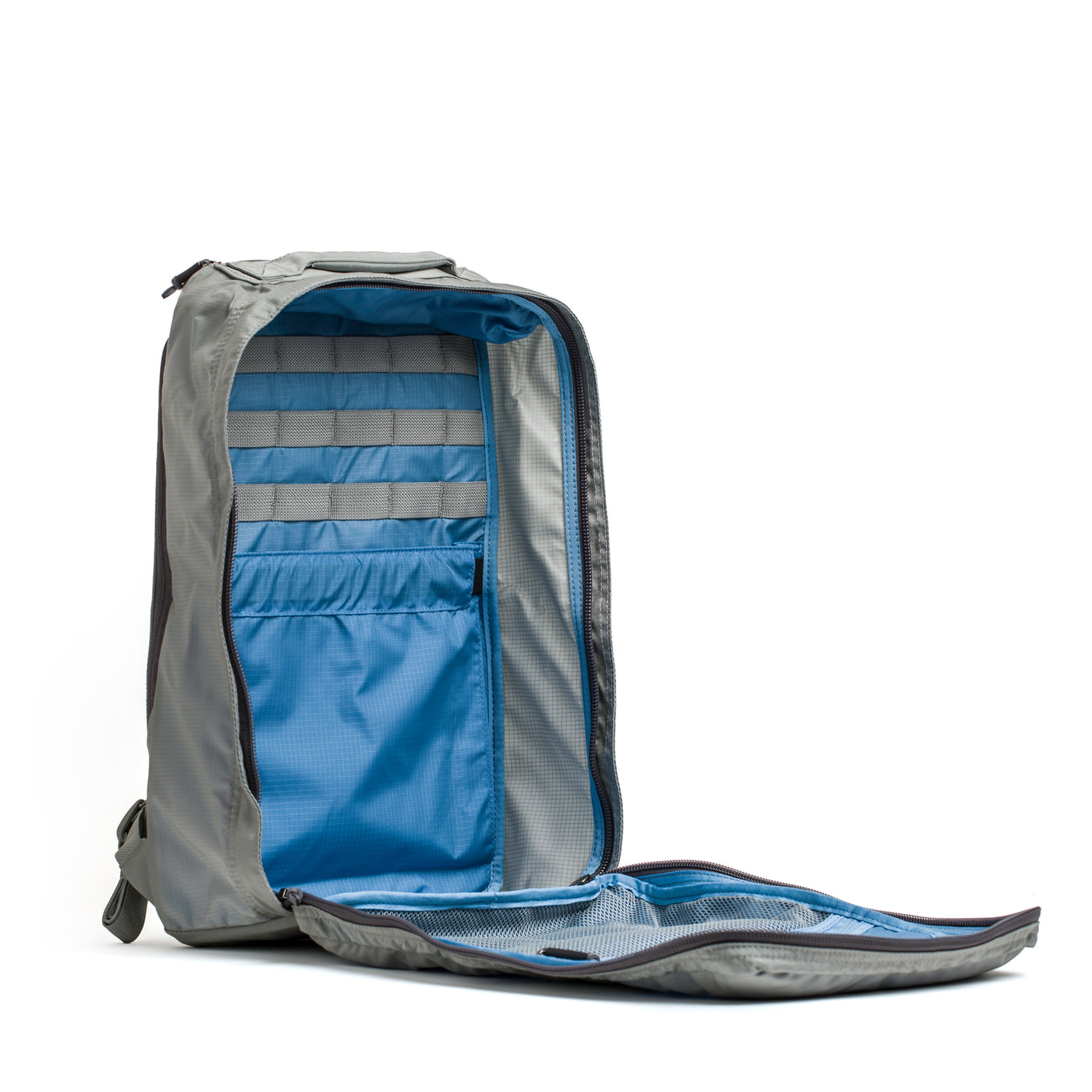 The GR1 USA - Ripstop ROBIC® backpack by GORUCK, featuring an open gray design made from ultra-lightweight Ripstop Nylon with a water-resistant finish, unveils its blue interior and organized storage compartments.