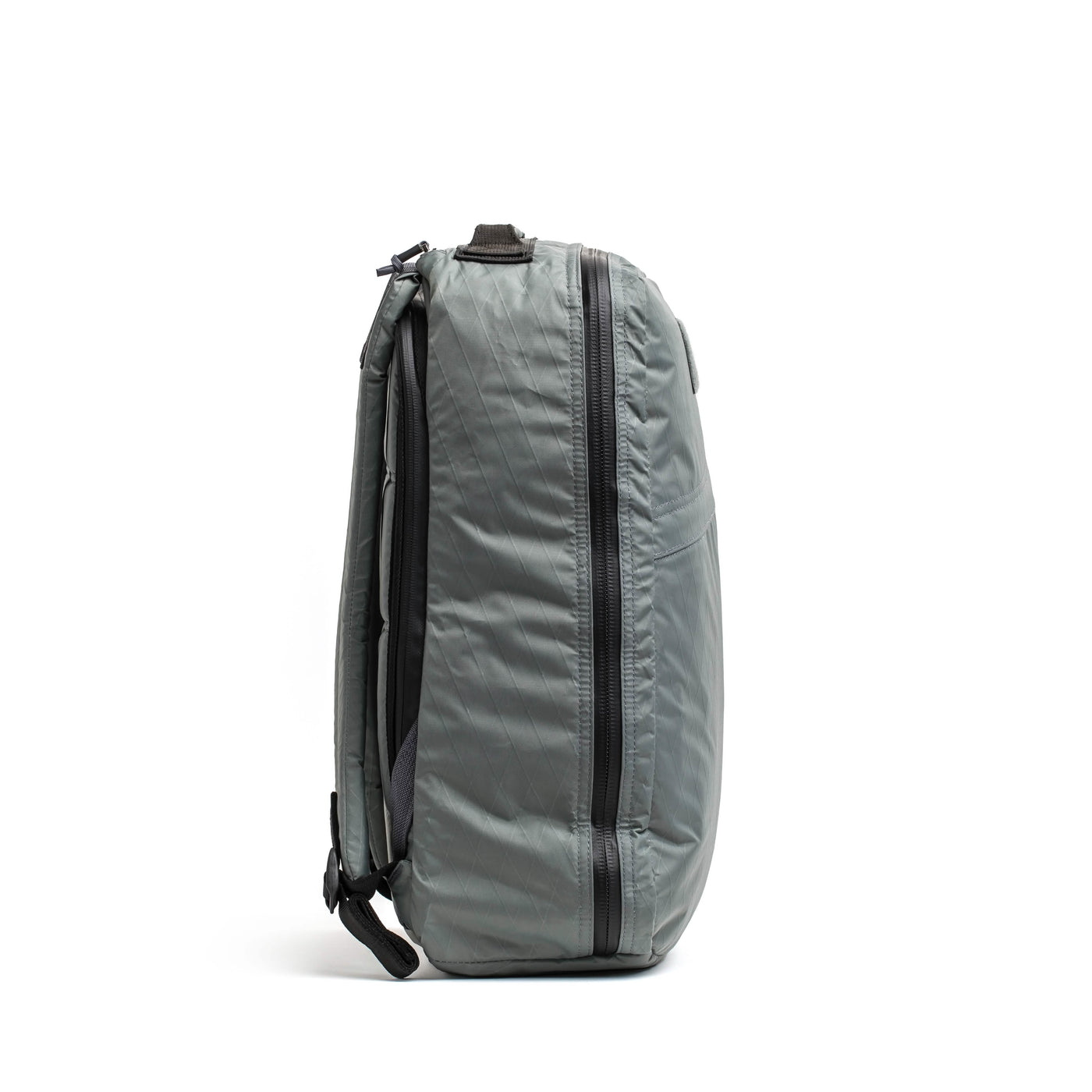 The GR1 USA - X-PAC by GORUCK is shown in a side view, showcasing its sleek design crafted with X-PAC material. It features a prominent large vertical zipper, adjustable shoulder straps, and waterproof capabilities. Its durable construction makes it ideal for travel or daily use.