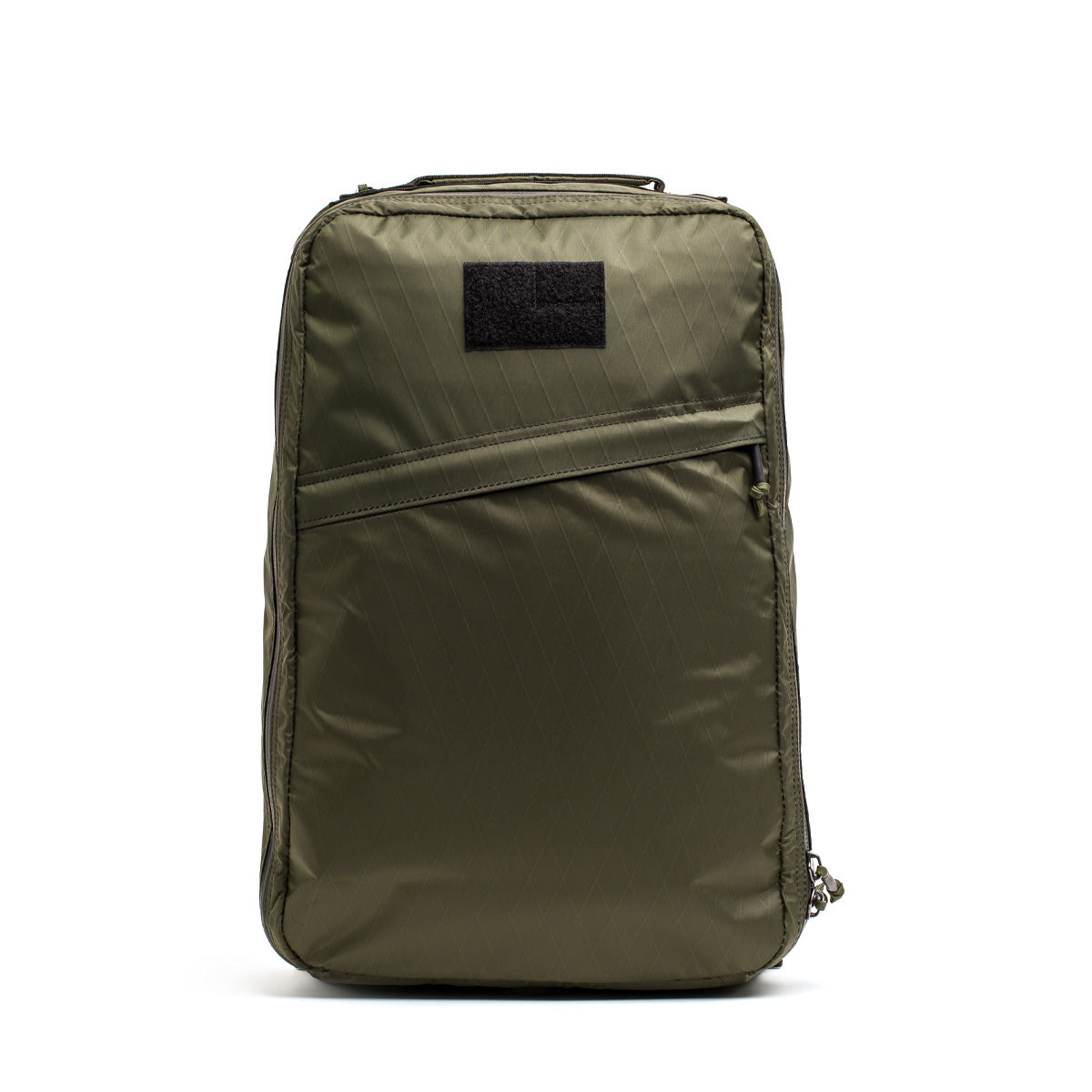 The olive green GORUCK GR1 USA - X-PAC rectangular rucksack boasts a front zippered pocket and a black patch on top, offering both style and waterproof features.