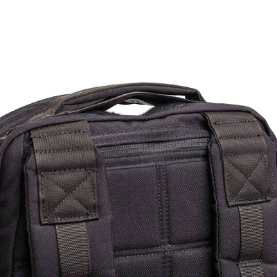 Close-up of the GR1 USA Throwback backpack's top handle and shoulder straps, crafted from durable 1680 Ballistic Nylon, with visible stitching and a zipper pocket.