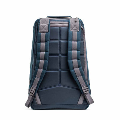 A rear view of the dark blue GR1 USA - Cordura (The Original Ruck), crafted with Special Forces grade materials, featuring padded straps and a top handle, ideal for the GORUCK Challenge, against a white background.