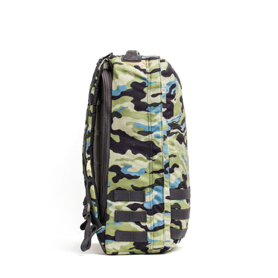 Side view of a GORUCK GR1 USA - Cordura backpack featuring black, green, blue, and beige camouflage patterns on a white background, exemplifying the rugged style preferred by Special Forces.