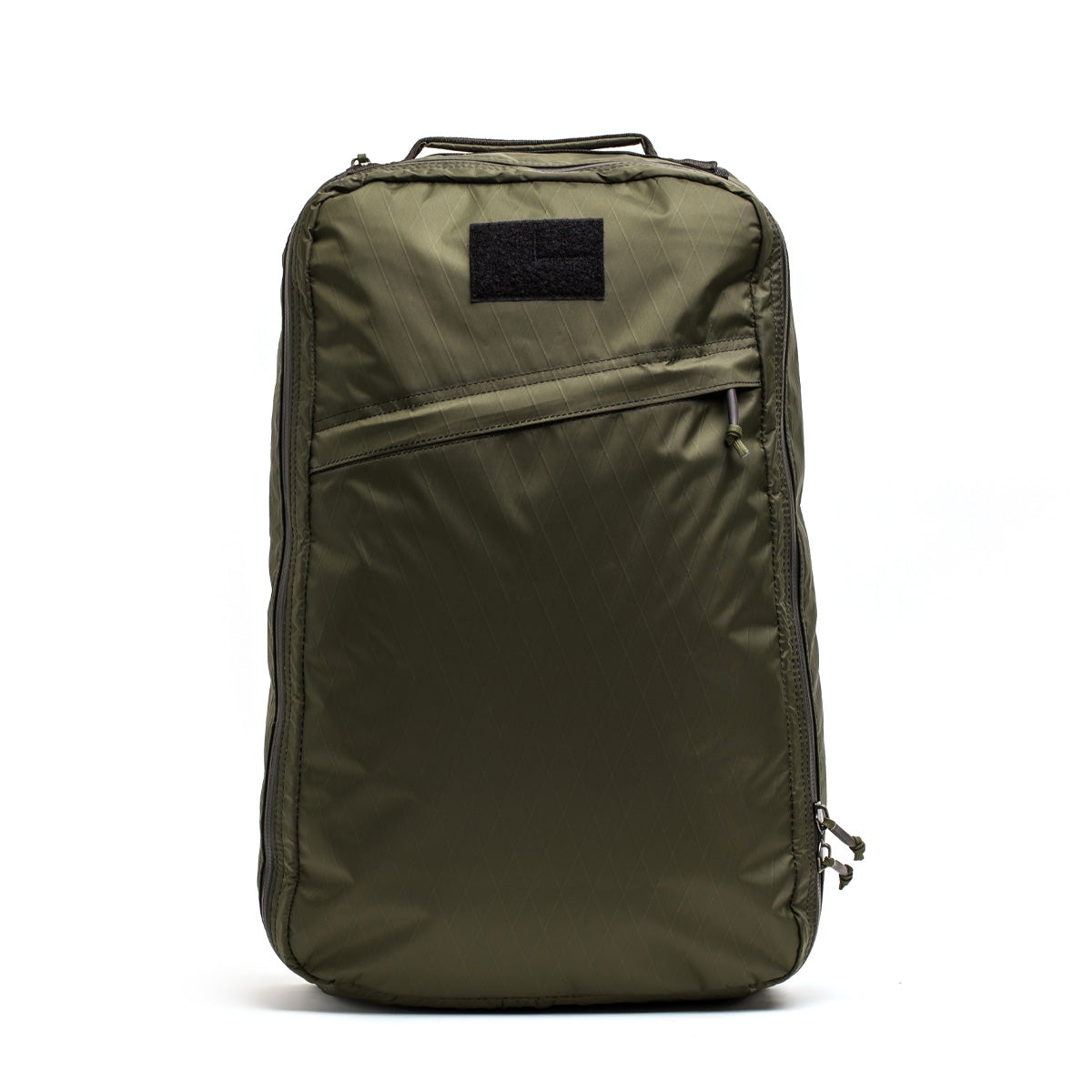 The GR1 USA - X-PAC by GORUCK is a green, durable travel backpack equipped with a handle, front zipper pocket, and a black patch on top. This waterproof rucksack is an ideal choice for adventurers seeking reliable gear.