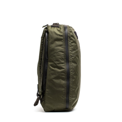 Side view of a GORUCK GR1 USA - X-PAC rucksack in green with zippers, displayed on a white background to highlight its waterproof design.