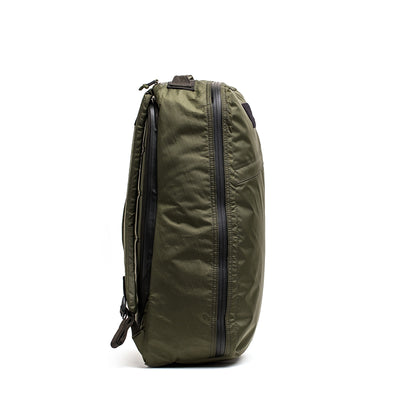 The GR1 USA - X-PAC in green showcases its sleek design with durable X-PAC fabric and zippers, presented from a side angle against a white backdrop.