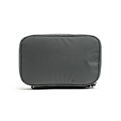 Introducing the GORUCK GR1 Field Pocket USA - X-PAC, a sleek and practical gray quilted travel pouch featuring side zippers. Its minimalist design and consistent color enhance its functionality for convenient on-the-go storage, with a soft, visible texture that combines both style and utility.