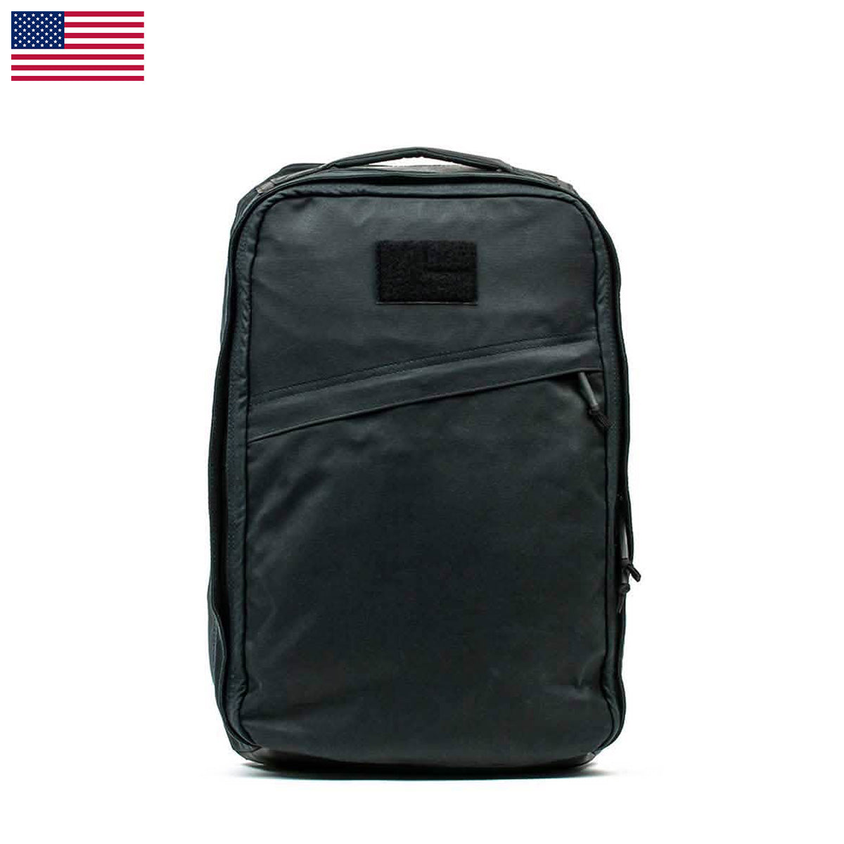 The GR1 USA - Heritage backpack in black, crafted from durable materials, features a front pocket and small patch area, perfectly showcased against a white background with a USA flag icon.