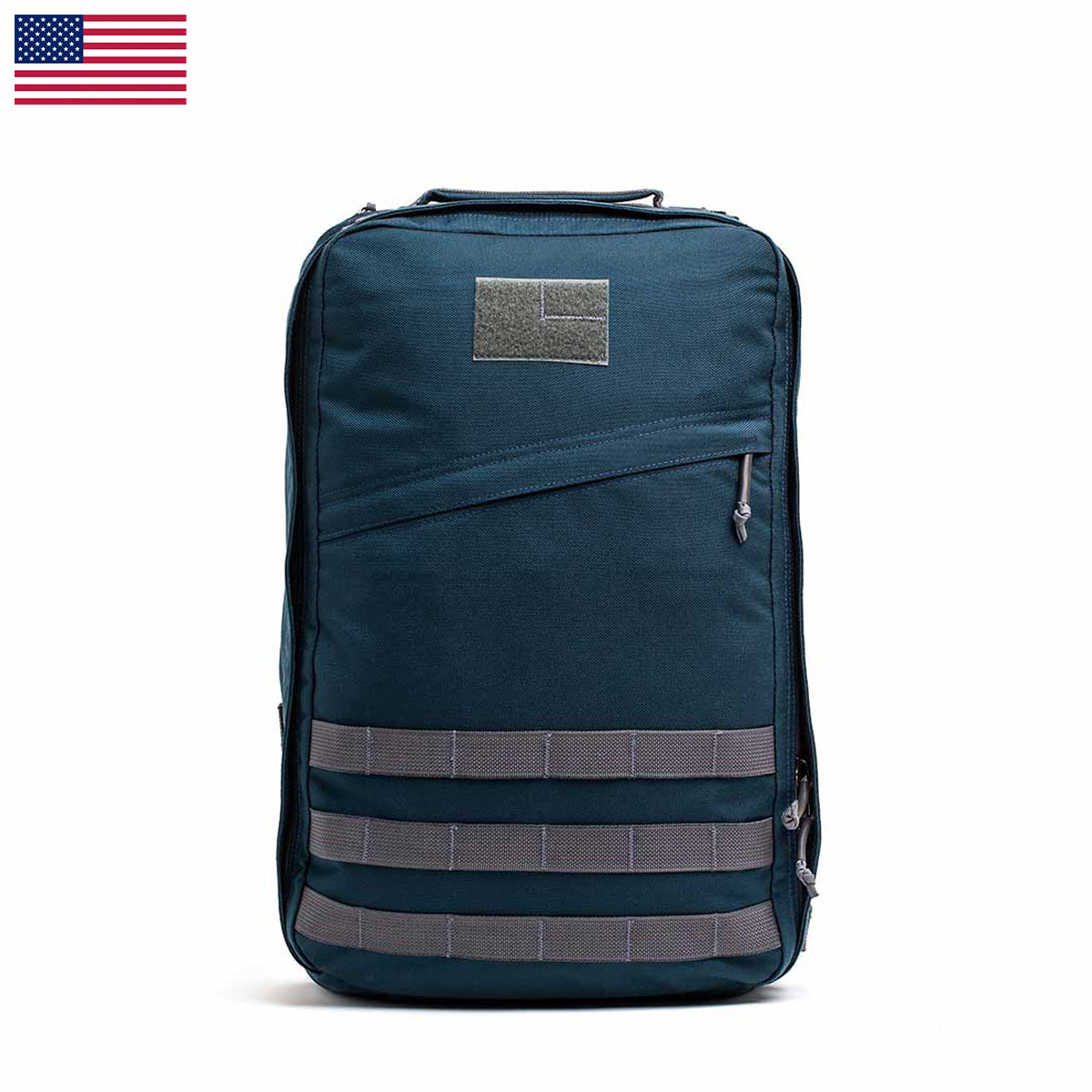 The GR1 USA - Cordura backpack, with grey straps and a patch, is crafted from Special Forces grade materials. Set against a white background with a small USA flag in the top left corner, it embodies the spirit of the GORUCK Challenge.