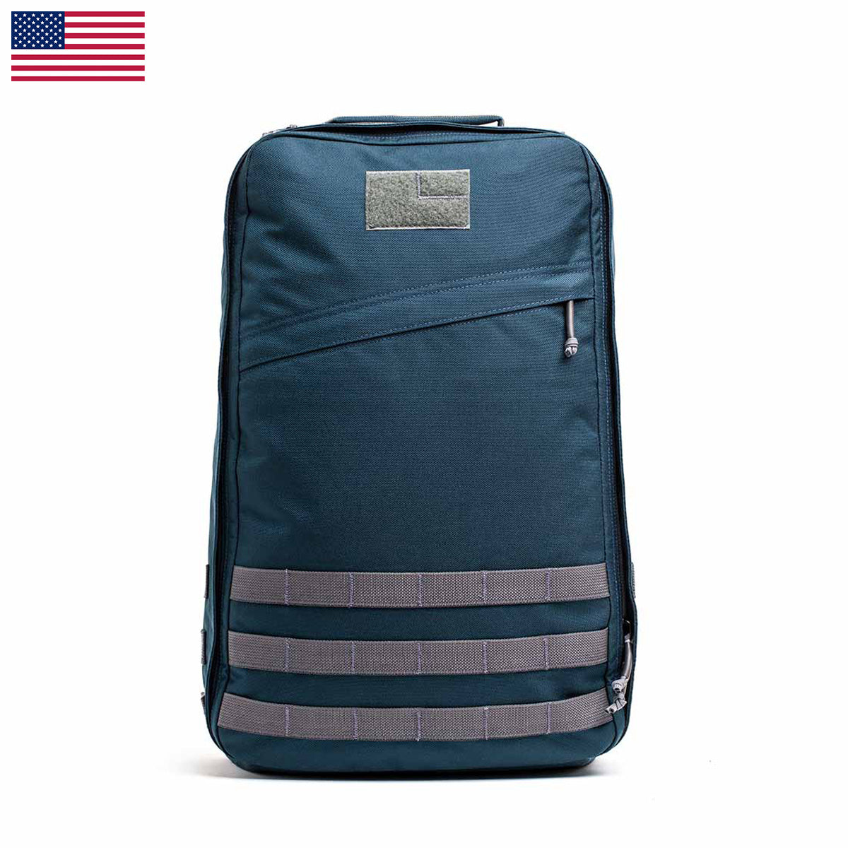 The GR1 USA - Cordura backpack, known as The Original Ruck, features blue fabric with gray accents and a top zipper. Constructed from Special Forces grade materials, it includes a small American flag in the top left corner—ideal for your next GORUCK Challenge.