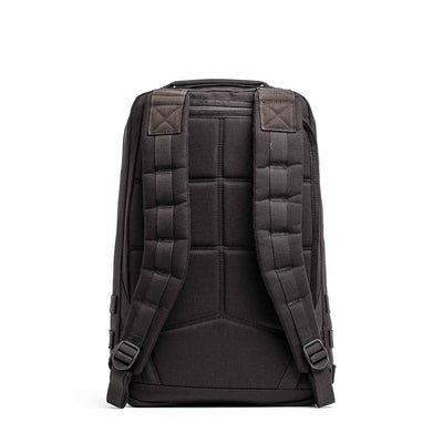 The GR1 USA Throwback is a black backpack crafted from durable 1680 ballistic nylon, featuring a bombproof laptop compartment, padded straps, and a top handle, viewed from the back against a white background.