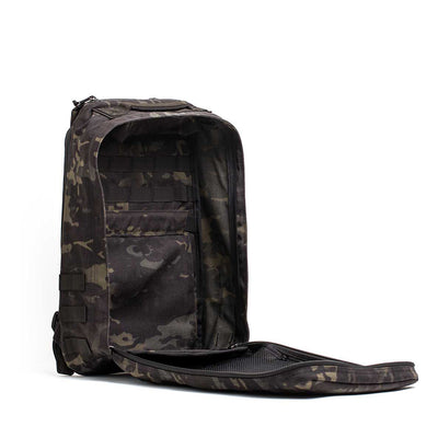 The GR1 USA - Cordura (The Original Ruck) backpack, designed with Special Forces grade materials, features a camouflage pattern, spacious open compartment, sleek black exterior, and visible internal pockets—perfect for any adventure or GORUCK Challenge.