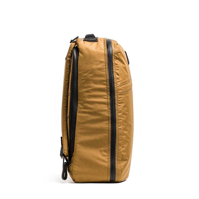 Side view of the GR1 USA - X-PAC brown rucksack against a white background, showcasing a black zipper and handle, crafted from X-PAC material for superior waterproof performance.