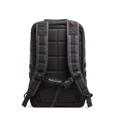 The GR2 - Dyneema by GORUCK is a stylish and functional black backpack made with abrasion-resistant materials. It boasts padded shoulder straps and horizontal stitching on the back, while black buckles complement the branded strap across the lower back, ensuring both durability and style for any adventure.