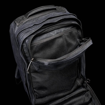 A GR2 - Waxed Canvas by GORUCK rests against a plain black background, its multiple zippered compartments open wide. The interior boasts mesh pockets and a spacious design, ensuring organization and easy access for all your essentials.