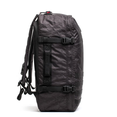 Side view of the spacious GR3 - Dyneema backpack by GORUCK, crafted from durable Dyneema material. It features multiple straps and buckles and is designed for heavy-duty use with padded shoulder straps for added comfort. Ideal as a carry-on backpack, it includes the Scars Lifetime Guarantee.