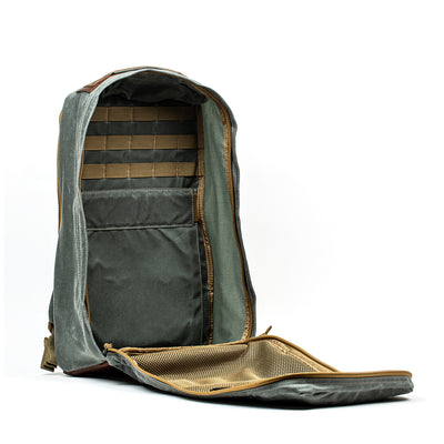 The GR1 USA - Heritage by GORUCK is unzipped, showcasing its meticulously arranged interior. This rucksack has numerous compartments, including pockets and mesh sections for superior organization. Set against a plain white background, it exudes a blend of classic style and practicality.