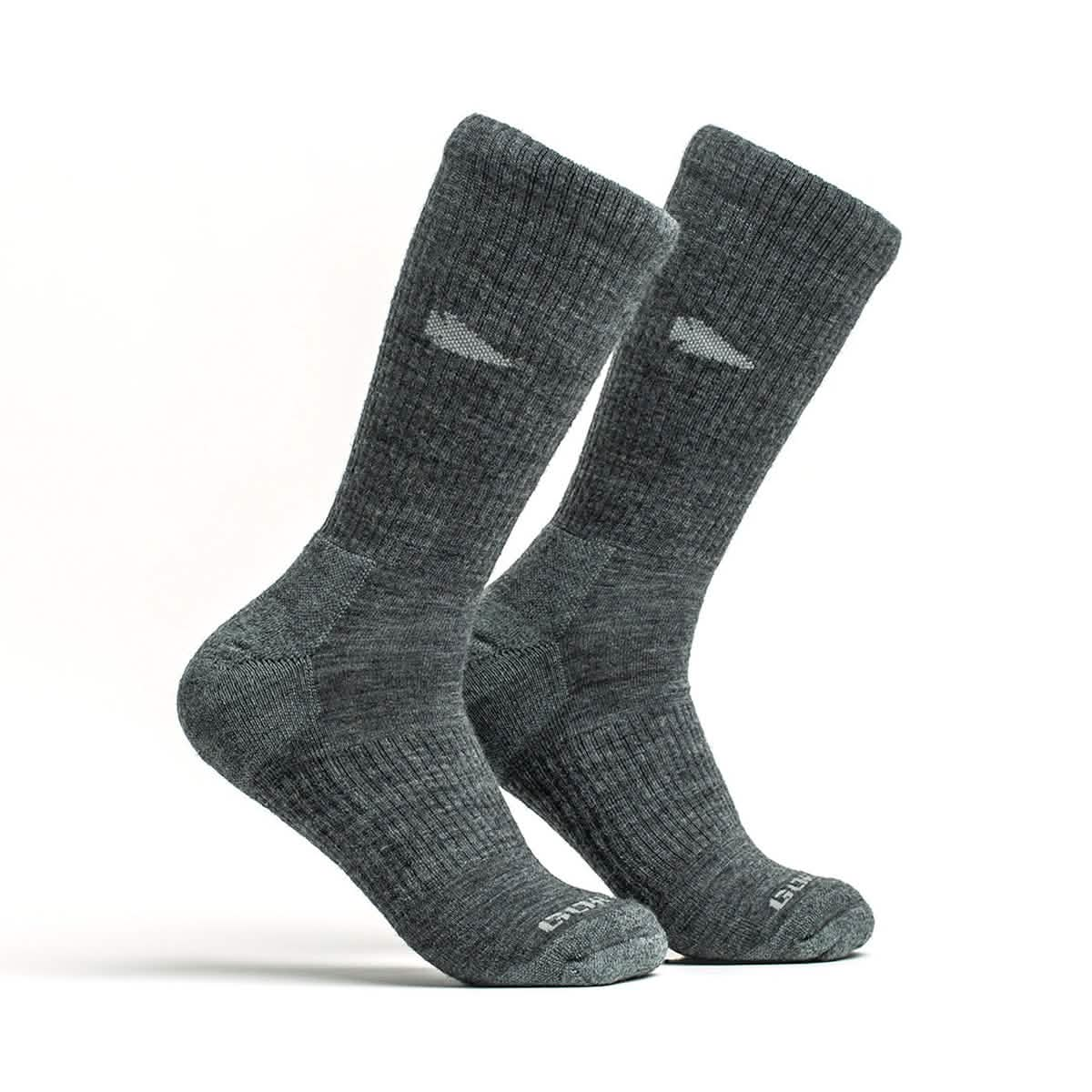 A pair of Merino Challenge Socks 1.0 - Crew by GORUCK stands upright on a plain white background, highlighting their slightly ribbed texture and a subtle logo near the cuffs. Experience comfort and durability with the Scars Lifetime Guarantee.