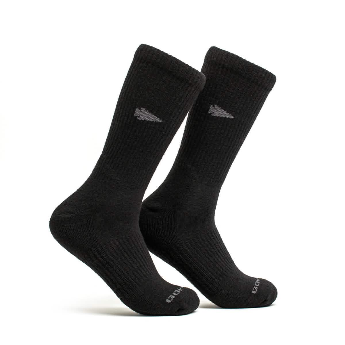 The GORUCK Merino Challenge Socks - Crew are shown standing upright against a plain white background, showcasing their ribbed texture and cushioned toe. These black socks feature a subtle logo near the top and provide ideal comfort for boot height wear.