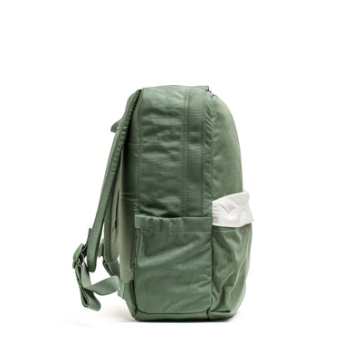 Side view of the GORUCK KR1 2.0 - Kid Ruck, a durable kids backpack in green, showcasing two pockets and reinforced stitching, with a white item tucked into one pocket.