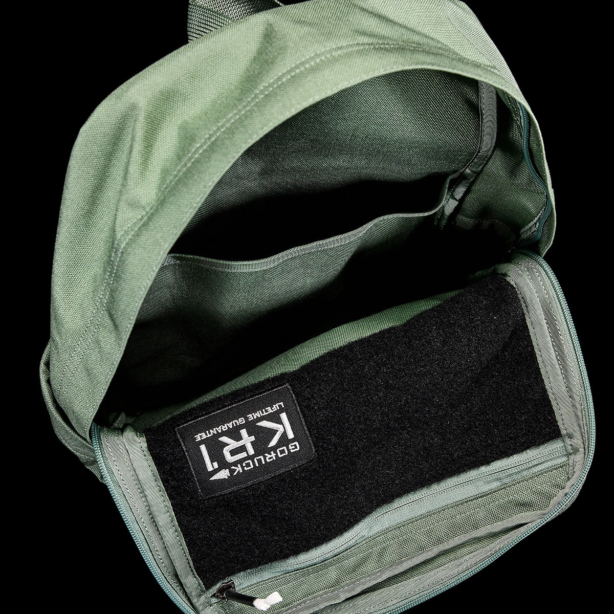 Introducing the KR1 2.0 - Kid Ruck by GORUCK: a green backpack designed for kids, featuring reinforced stitching, visible compartments, and an interior patch.