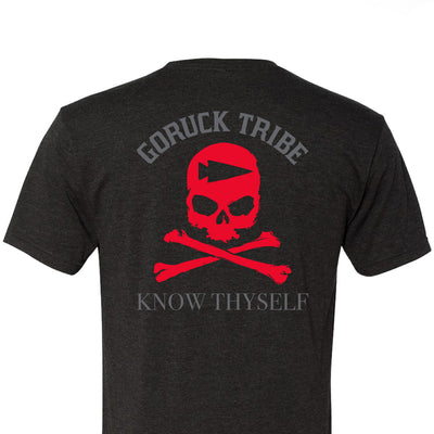 The GORUCK Know Thyself Tribe Tee - Tri-Blend is a black T-shirt with a red skull and crossbones, displaying "GORUCK TRIBE" and "KNOW THYSELF." Embrace the harder path in the spirit of the GORUCK Challenge.