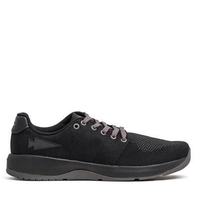 The Men's Ballistic Trainers from GORUCK, in a sleek Black + Black + Charcoal design with a Black Reflective Spearhead motif, are showcased. Ideal for functional fitness footwear, these shoes boast gray laces and a textured, CORDURA Ballistic Nylon sole that provides 3X stability. The slightly raised heel enhances performance, while the mesh upper ensures breathability.