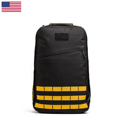 The GR1 USA - Cordura (The Original Ruck) by GORUCK is a black and yellow, durable backpack with molle webbing and an American flag in the corner, echoing the rugged design preferred by Special Forces.