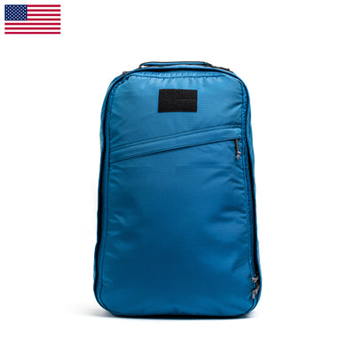 The GR1 USA - Ripstop ROBIC® travel rucksack by GORUCK stands upright, showcasing multiple zippers, an ultra-lightweight design, and a USA flag icon in the top left corner.