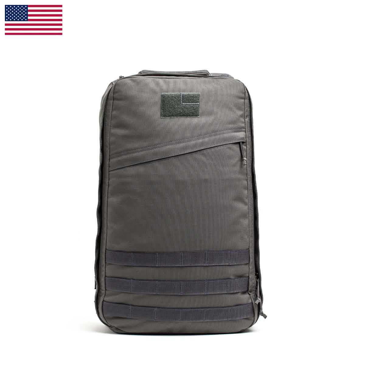 The GR1 USA - Cordura (The Original Ruck) by GORUCK, inspired by Special Forces design, boasts numerous compartments and straps. Displayed against a white background with a US flag icon, it symbolizes its commitment to American manufacturing excellence.