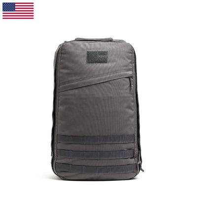 The GR1 USA - Cordura (The Original Ruck) by GORUCK, inspired by Special Forces design, boasts numerous compartments and straps. Displayed against a white background with a US flag icon, it symbolizes its commitment to American manufacturing excellence.