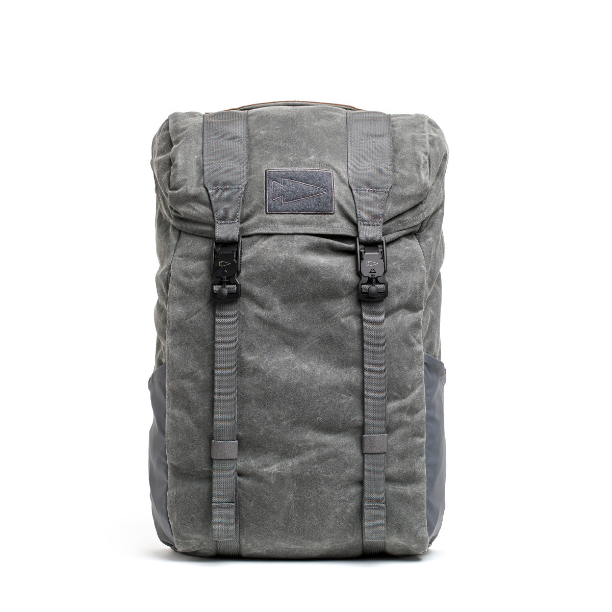 The GORUCK M24 - Waxed Canvas backpack captures a modern rucksack aesthetic with its weathered appearance, top flap, and two straps, reminiscent of the M23. It is beautifully set against a white background.