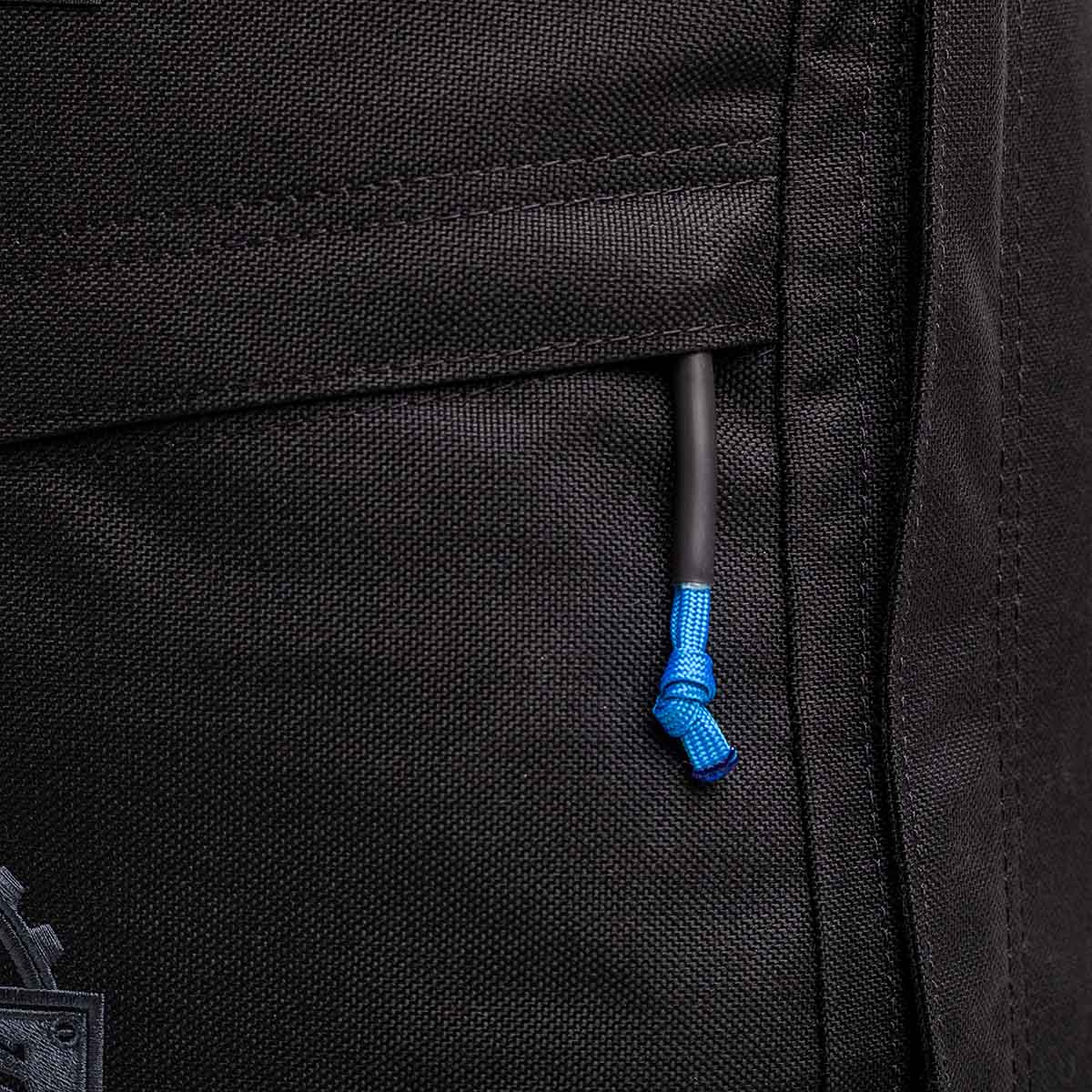 Close-up of a pocket with a blue drawstring on the textured fabric of this limited-edition GR1 USA - GORUCK X mikeroweWORKS black backpack, embodying American craftsmanship.